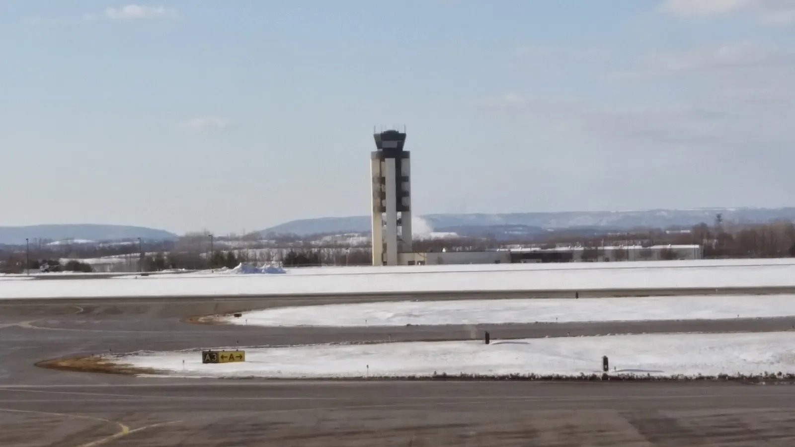 Air traffic control tower at Lehigh Valley International Airport against a clear sky.
