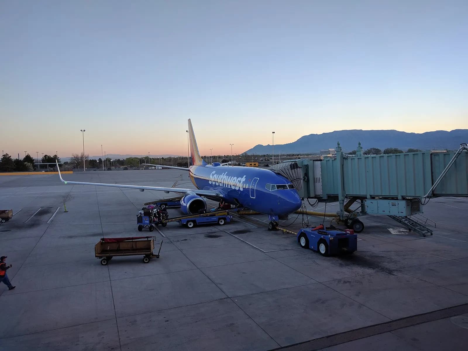 Southwest Airlines jet parked at a jet bridge at Albuquerque International Sunport at dawn.
