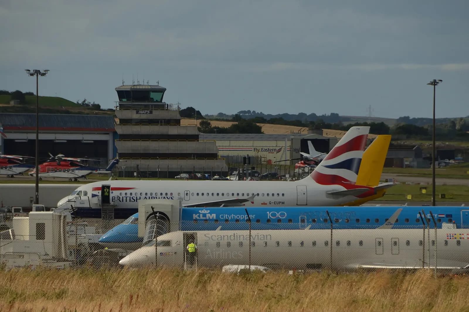 Fixed-wing aircraft on the apron with Aberdeen Airport’s control tower behind.