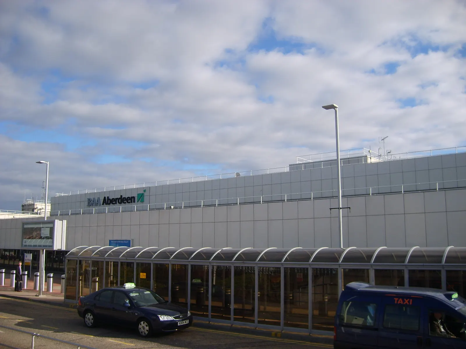 Wide exterior view of Aberdeen Airport terminal building under a clear sky.