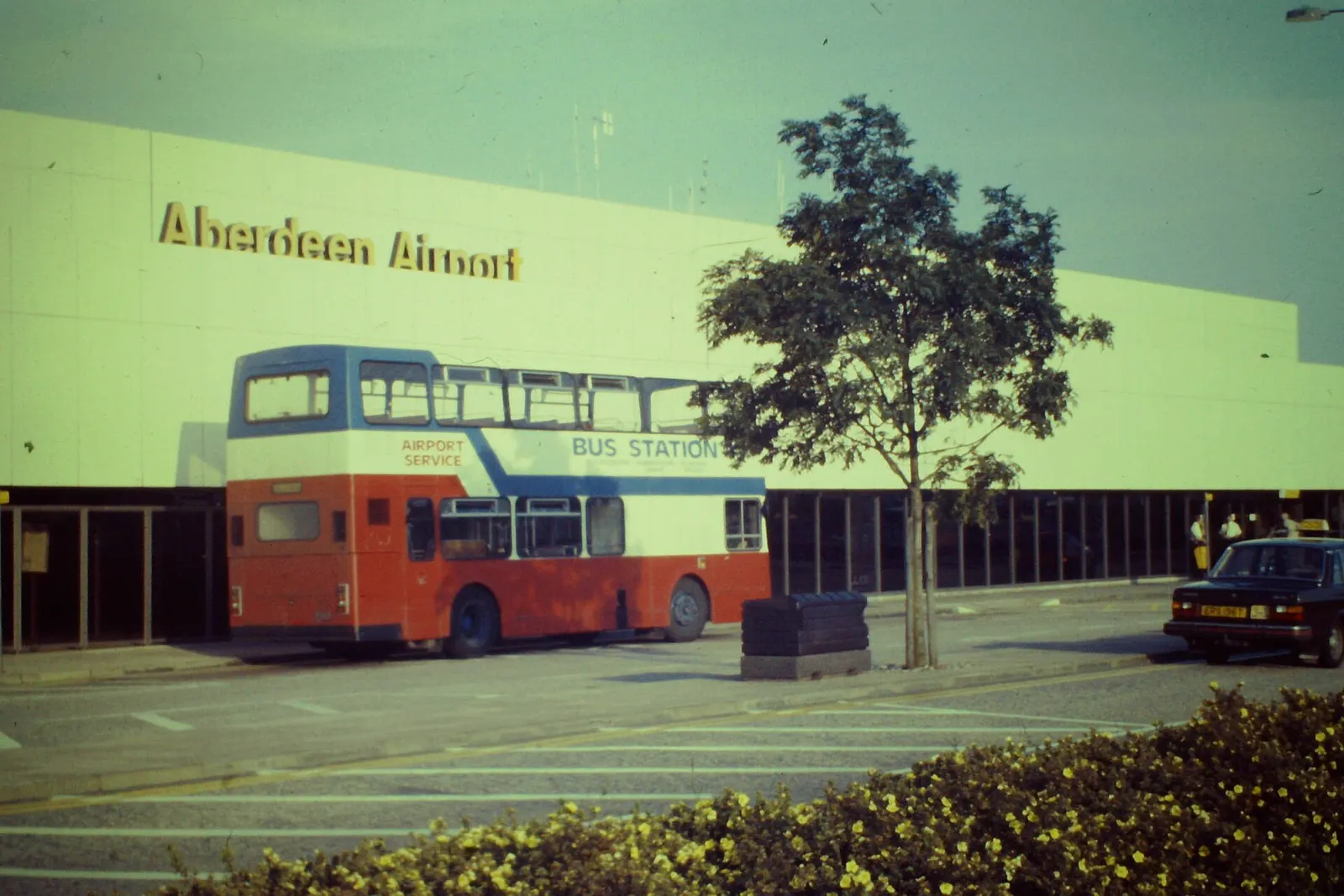 Double-deck city bus waiting outside Aberdeen Airport terminal for the run to the bus station.