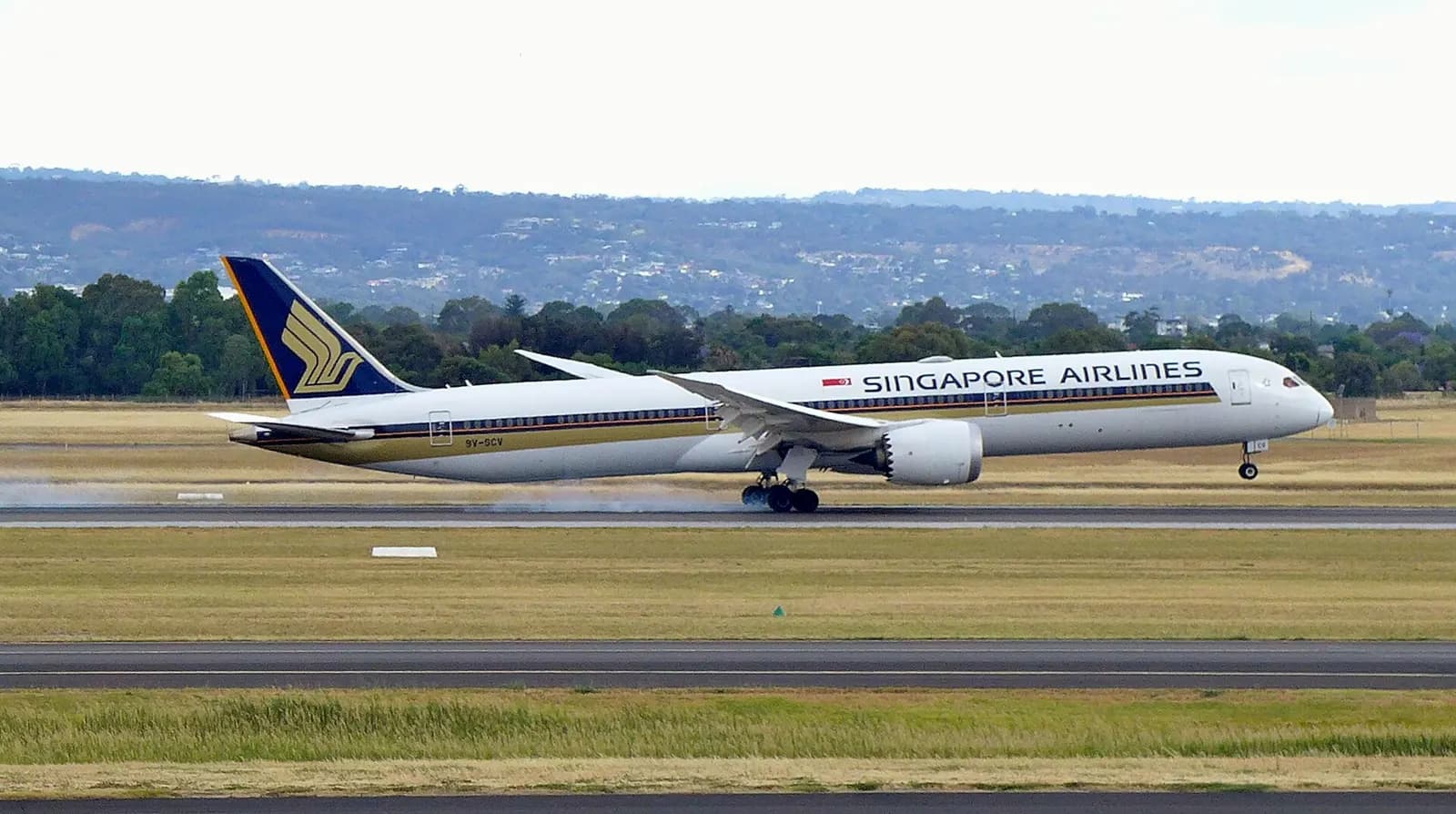 Singapore Airlines Boeing 787-10 9V-SCV landing on runway 23 at Adelaide Airport (ADL/YPAD), South Australia, at the end of a flight from Singapore (SIN/WSSS) as SQ277 – photo taken from inside the terminal