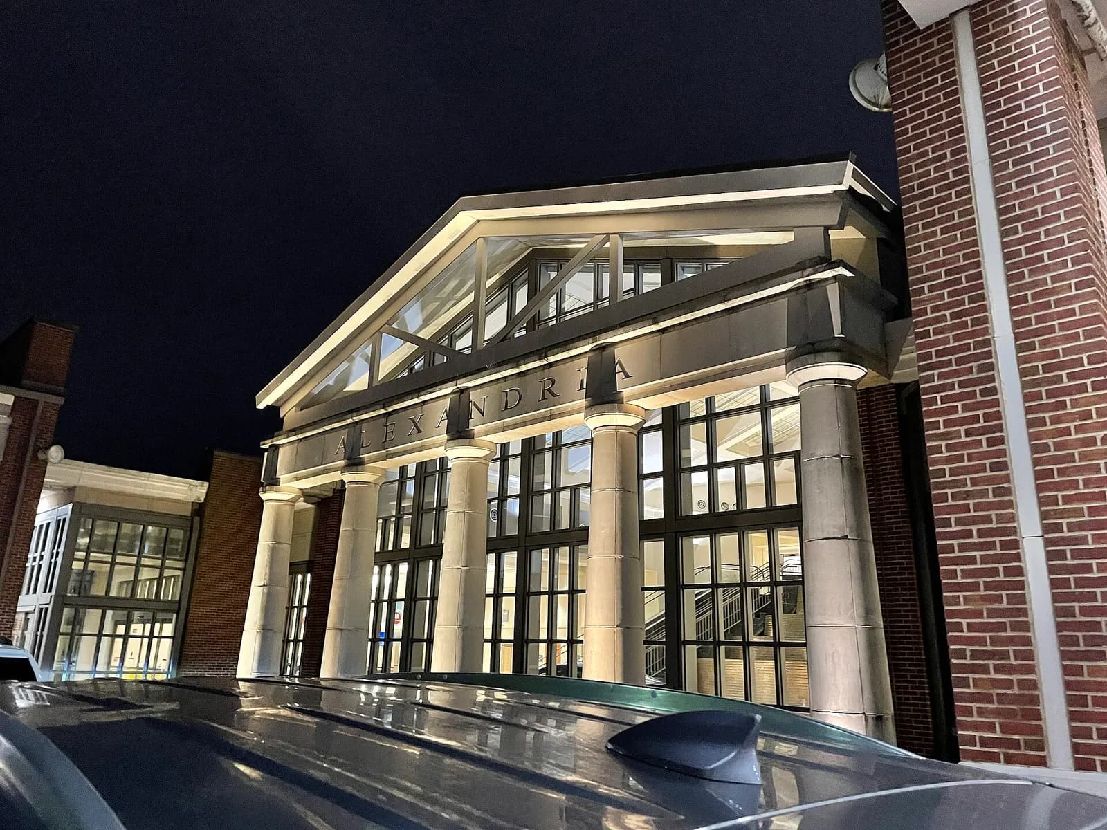 Night view of the columned ALEXANDRIA portico on the passenger terminal at Alexandria International Airport.