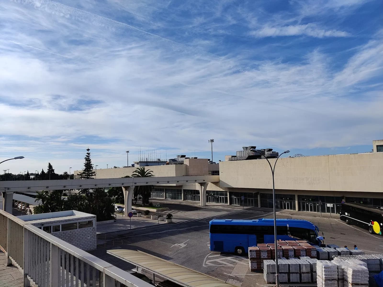 Inside Terminal 1 at Málaga Airport, travelers move through a bright concourse with departure screens, seating, and check-in zones visible.