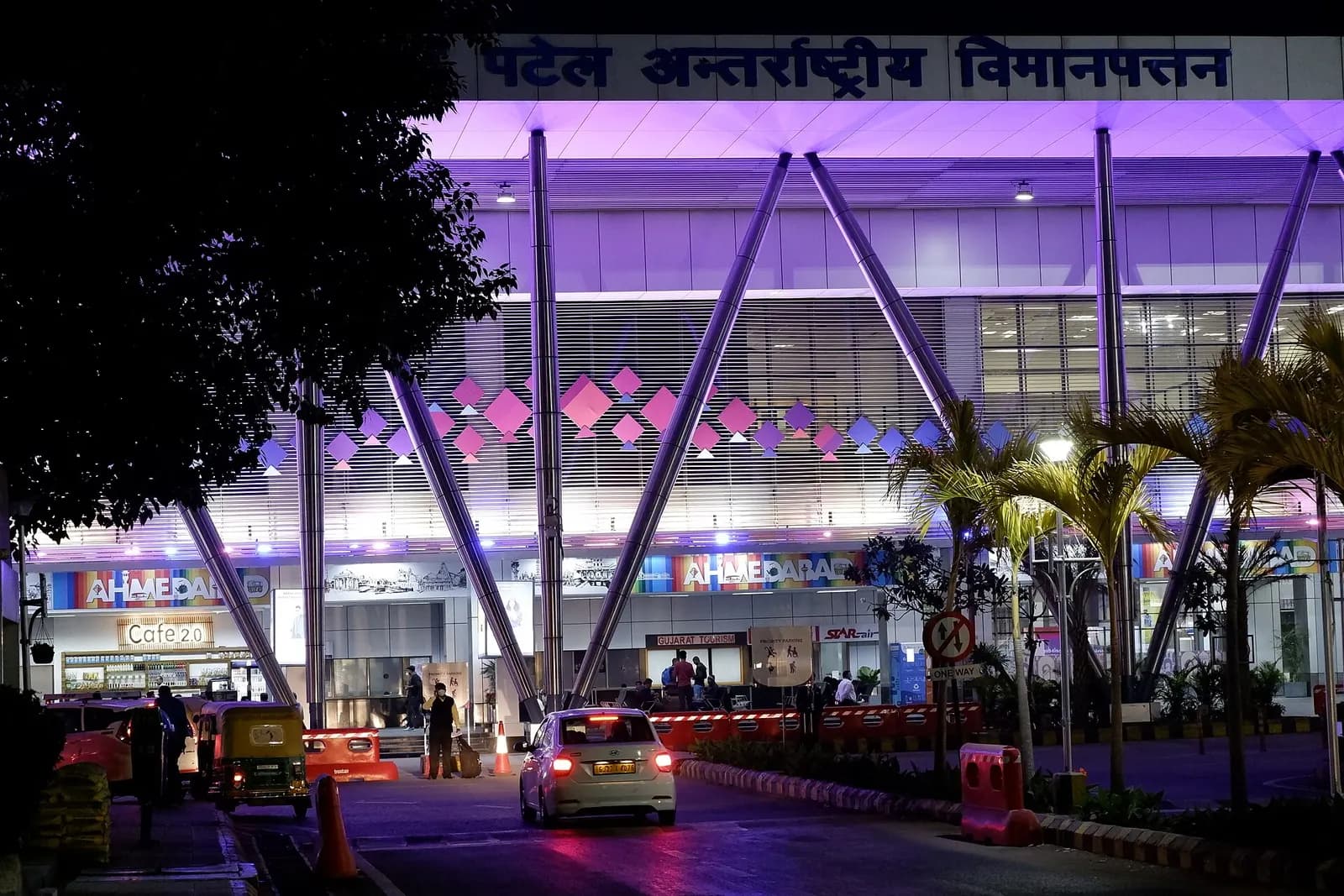 Night landside facade of Ahmedabad airport with AHMEDABAD signage and V-columns