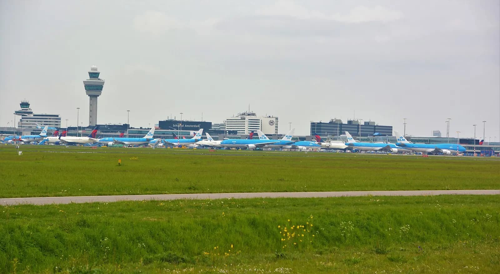 Schiphol's central terminal complex and surrounding taxiways seen from the official Buitenveldertbaan spotting area.