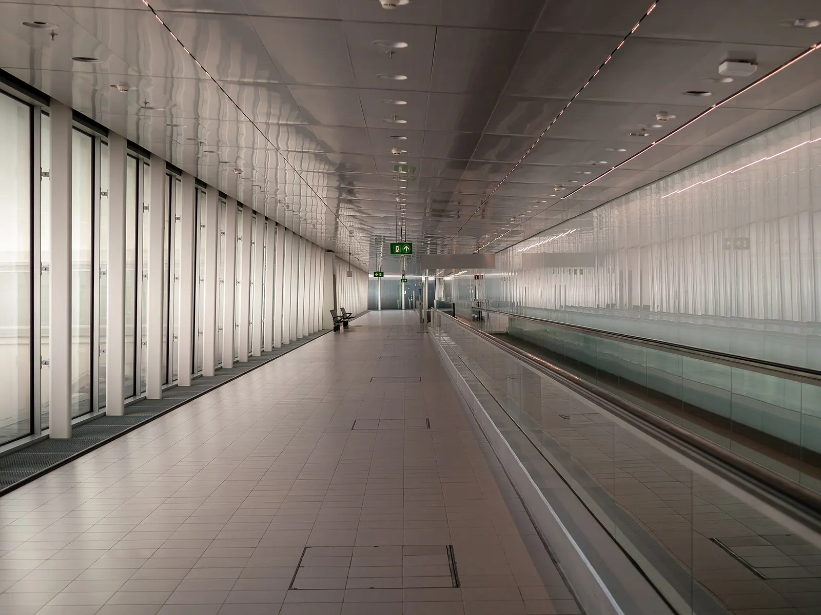 The international arrivals concourse at Schiphol with wide walkways, signage, and passengers collecting luggage.