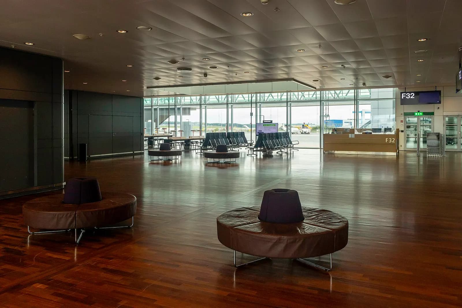 Bright, spacious check-in and departure hall inside Terminal 5 with ticket counters, signage, and travelers.