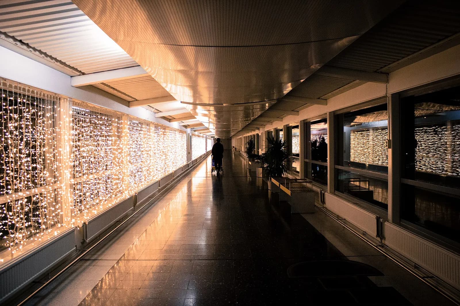 Long indoor pedestrian corridor connecting Terminals 3 and 4, with moving walkways and directional signs.