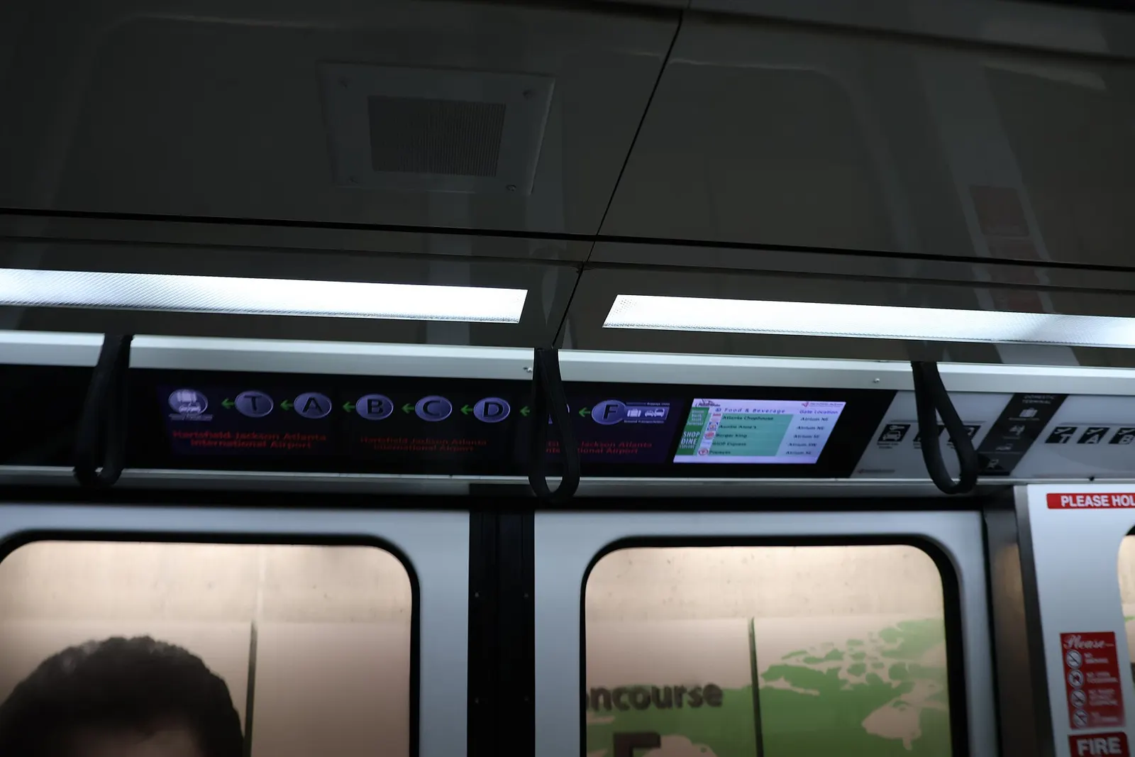 Passengers seated and standing inside an automated Plane Train car at Hartsfield-Jackson Atlanta International Airport as it runs between concourses.