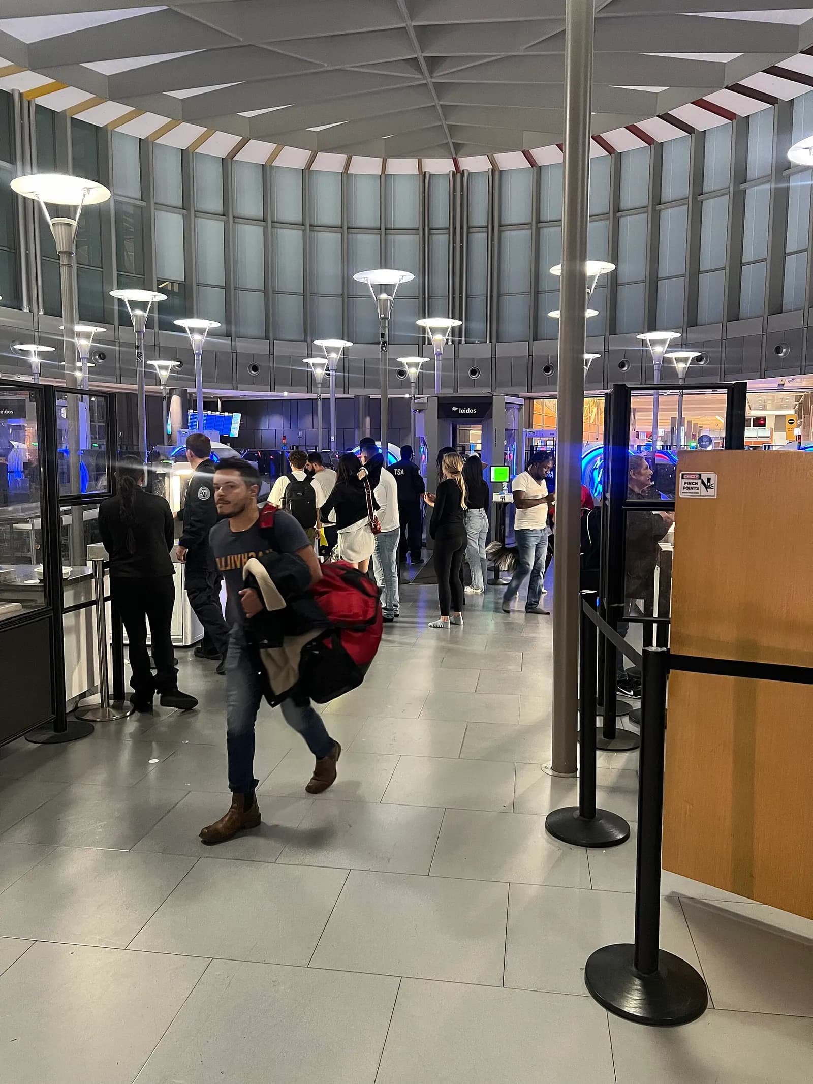 TSA security screening checkpoint at Austin–Bergstrom with queue lanes, divest bins, and body scanners under overhead signage.