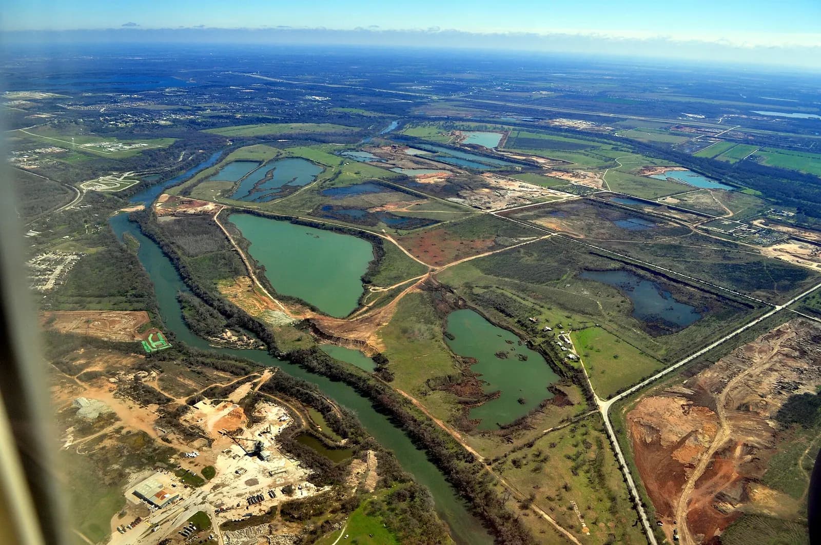 Aerial view of Colorado River north of Austin-Bergstrom International Airport, Austin, Texas, U.S. Looking roughly east. Center is at Object location 30° 15′ 06.37″ N, 97° 39′ 45.48″ W View this and other nearby images on: OpenStreetMap 30.251770; -97.662632