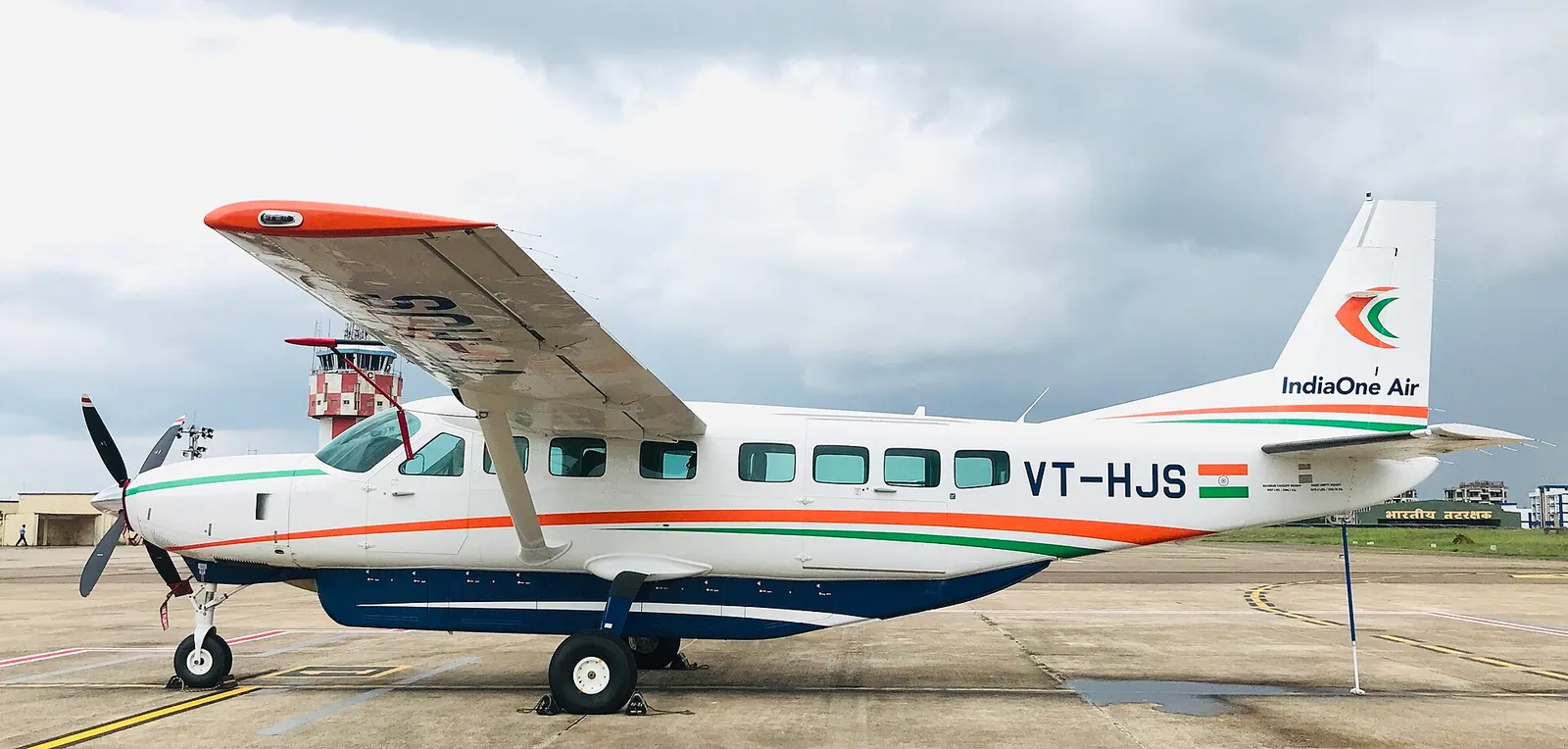 IndiaOne Air Cessna Grand Caravan EX VT-HJS on the apron at Biju Patnaik Airport with Coast Guard building behind