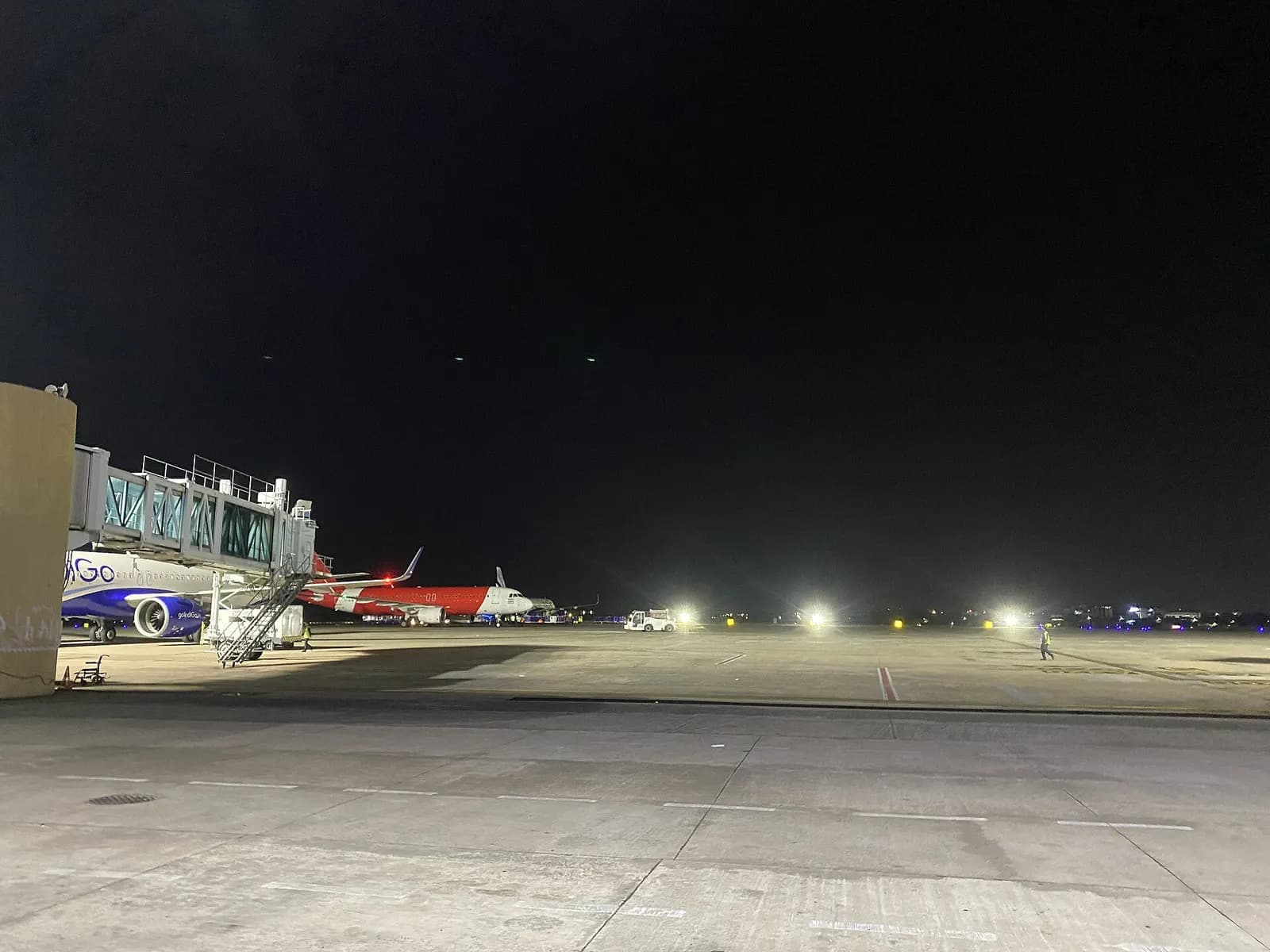 Night apron at Biju Patnaik Airport with IndiGo on a jet bridge and Air India Express in the background