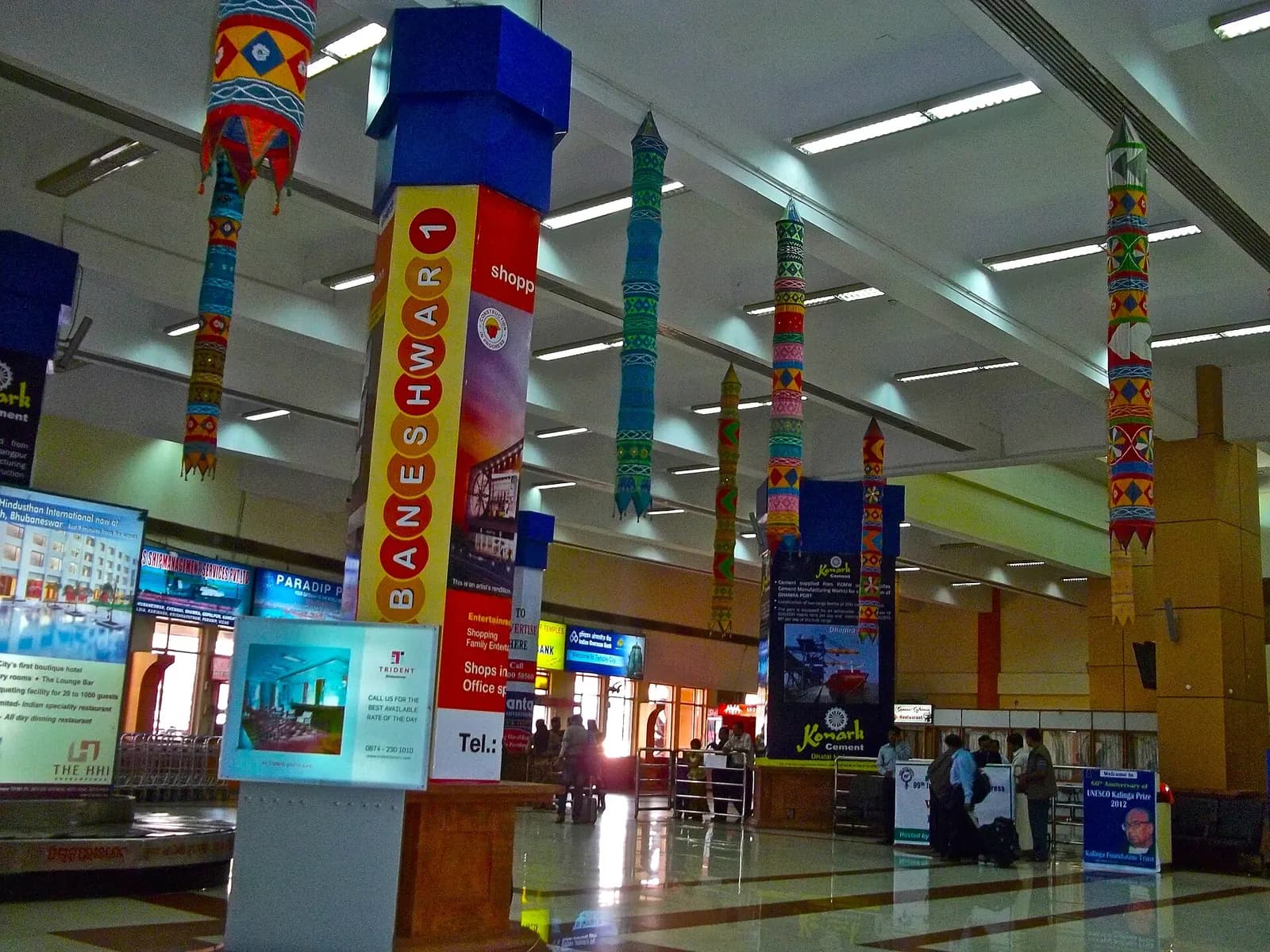 Check-in hall interior at Biju Patnaik Airport with Pipili appliqué hangings and Odisha tourism / hotel ads