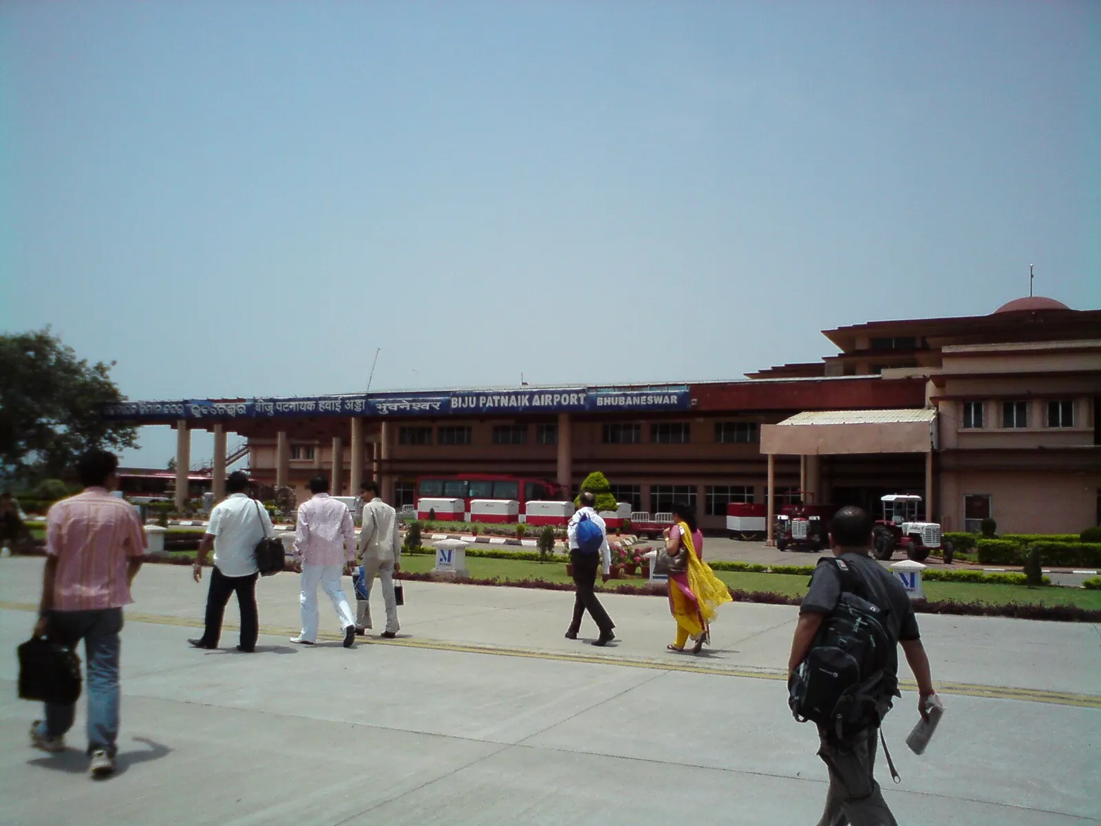 Landside approach to Biju Patnaik Airport Bhubaneswar with blue rooftop name board and passengers walking in