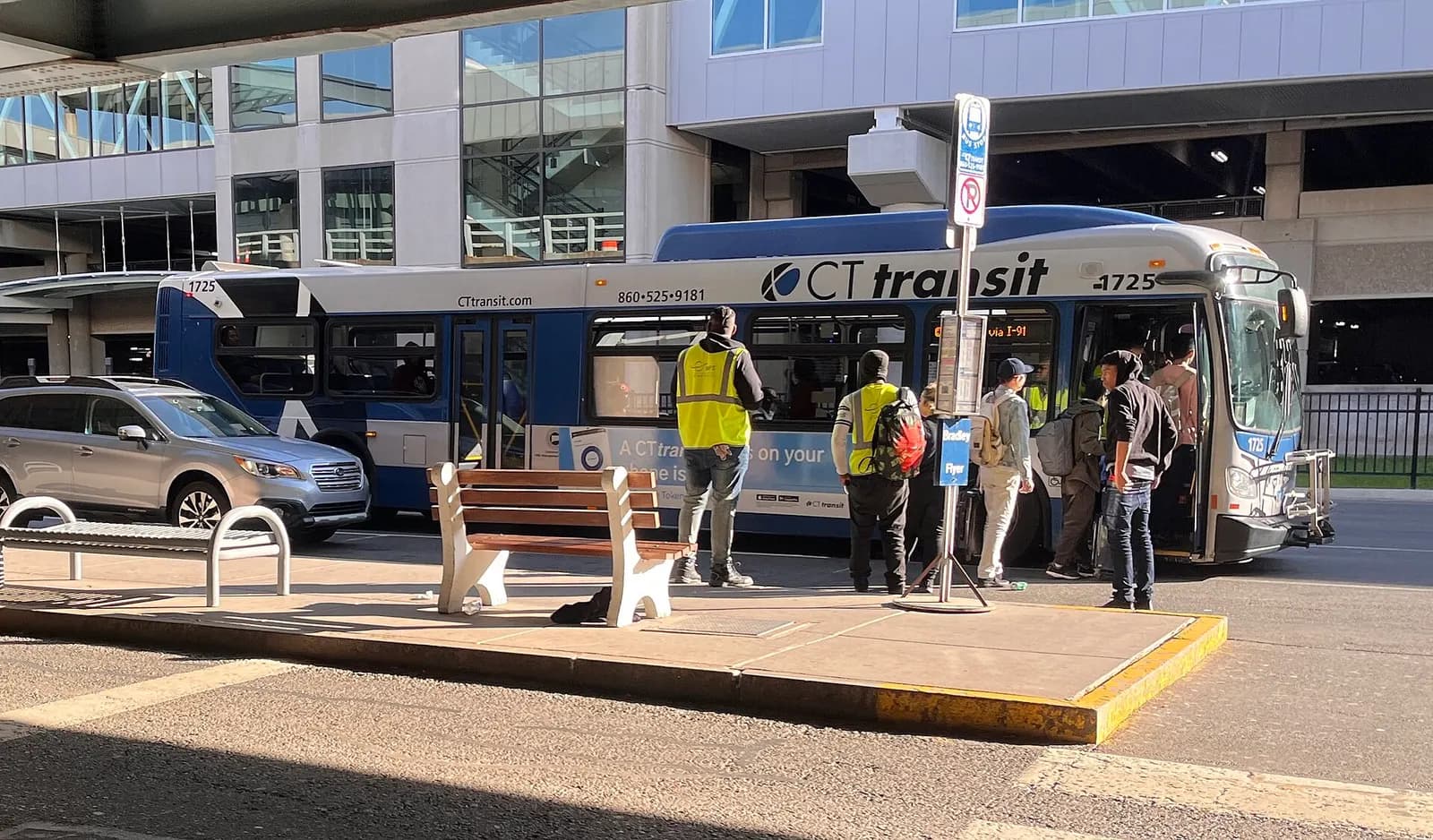 Passengers boarding a CTtransit Bradley Flyer bus at the airport curb under a Bradley Flyer sign