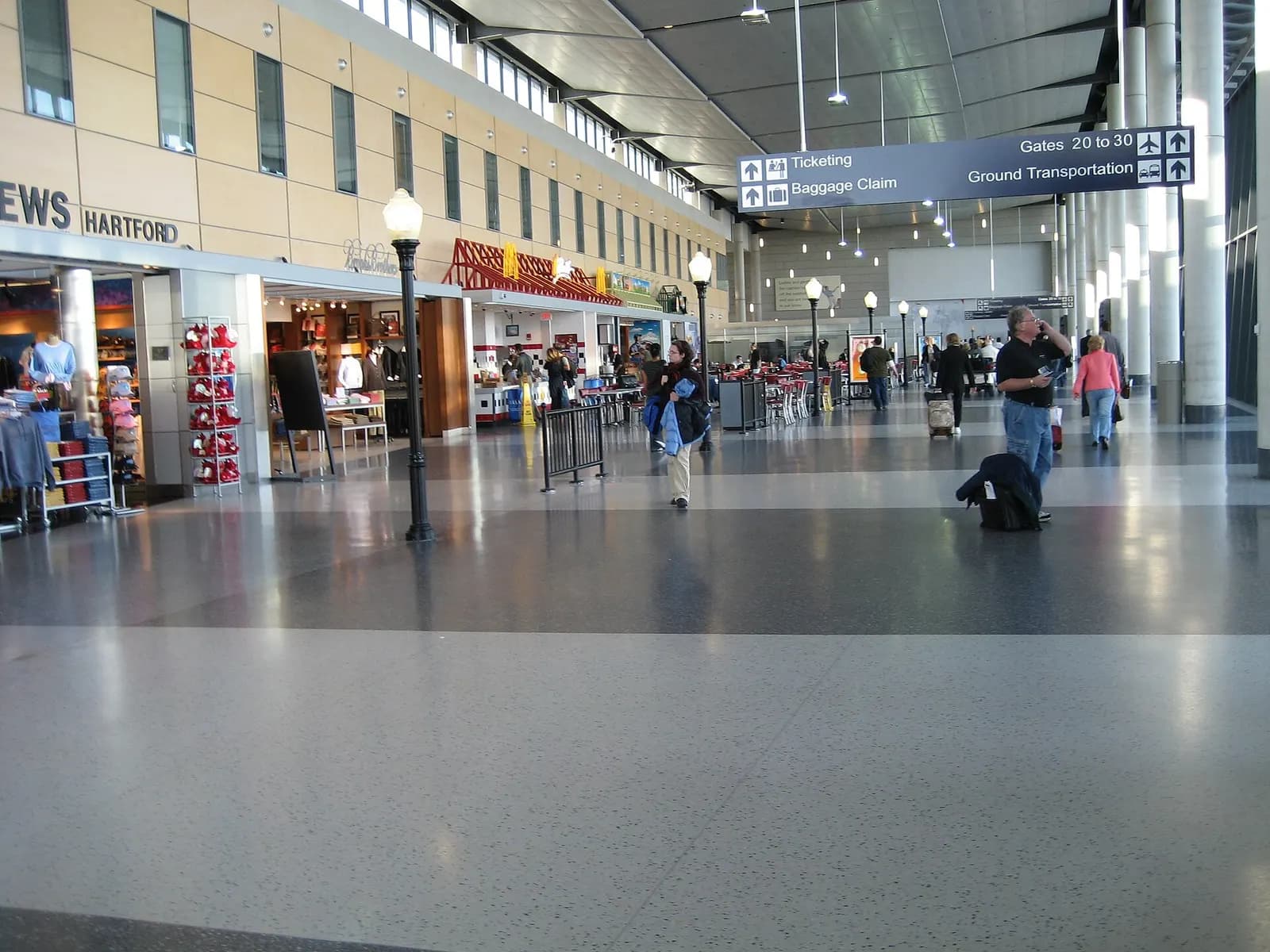 Bradley airside lobby with a Hartford sign, McDonald's, and overhead arrows to Gates 20–30 and ground transportation