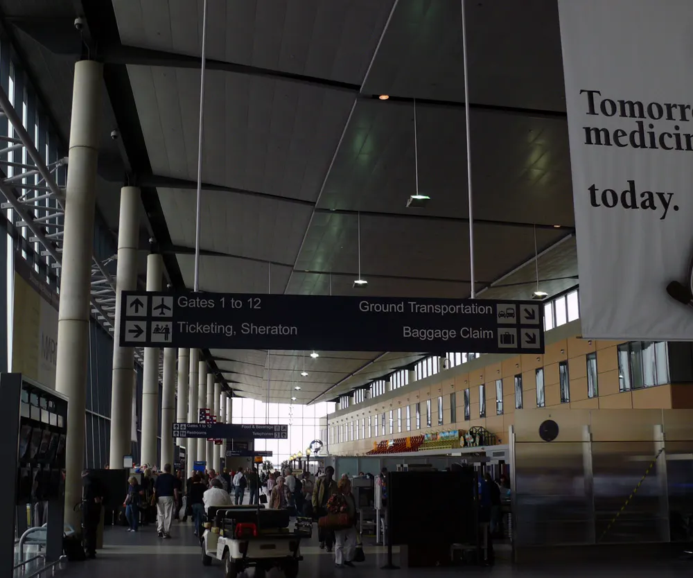 Bradley Terminal A hall with signs for Gates 1–12, the Sheraton, baggage claim, and ground transportation