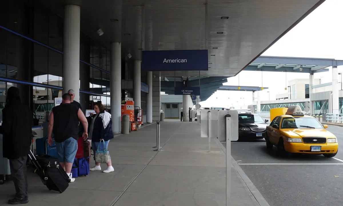 Bradley Terminal A departure curb with a Connecticut taxi under American check-in signs