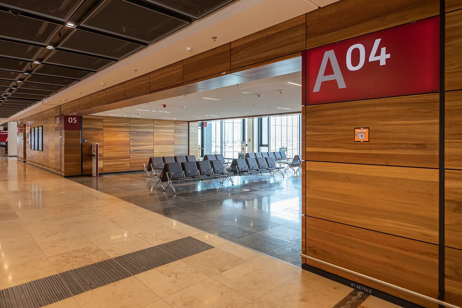 Gate A04 at Berlin Brandenburg Airport Terminal 1 shows a numbered gate sign, waiting seats, and boarding-bridge access in the gate lounge.