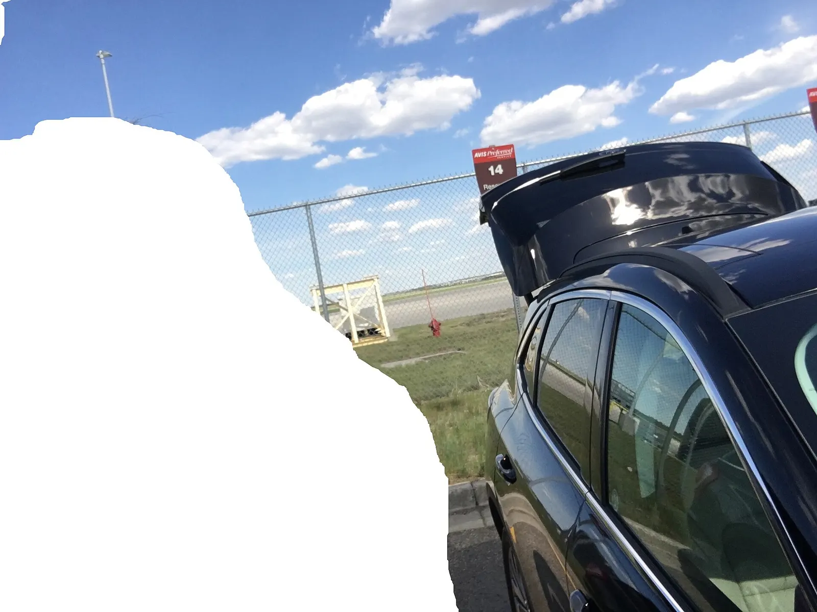 Rental-car ready lot and airfield pavement outside Bismarck Municipal Airport, with the runway complex beyond.