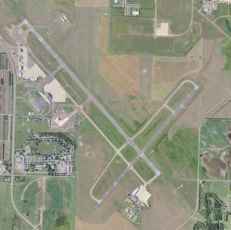 Overhead aerial photograph of Bismarck Municipal Airport showing both runways, taxiways, and the terminal apron.