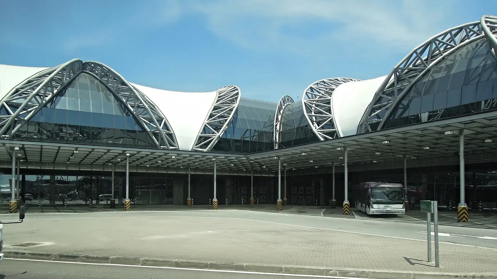 An indoor apron-bus loading area inside the terminal where passengers board low-floor buses to reach remote aircraft stands.