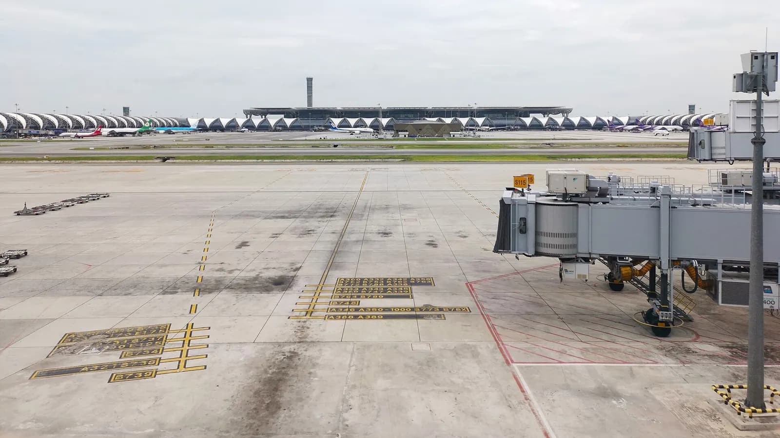 The exterior of Suvarnabhumi's Midfield Satellite Concourse with its modern glass-and-steel facade and connected airside structure.