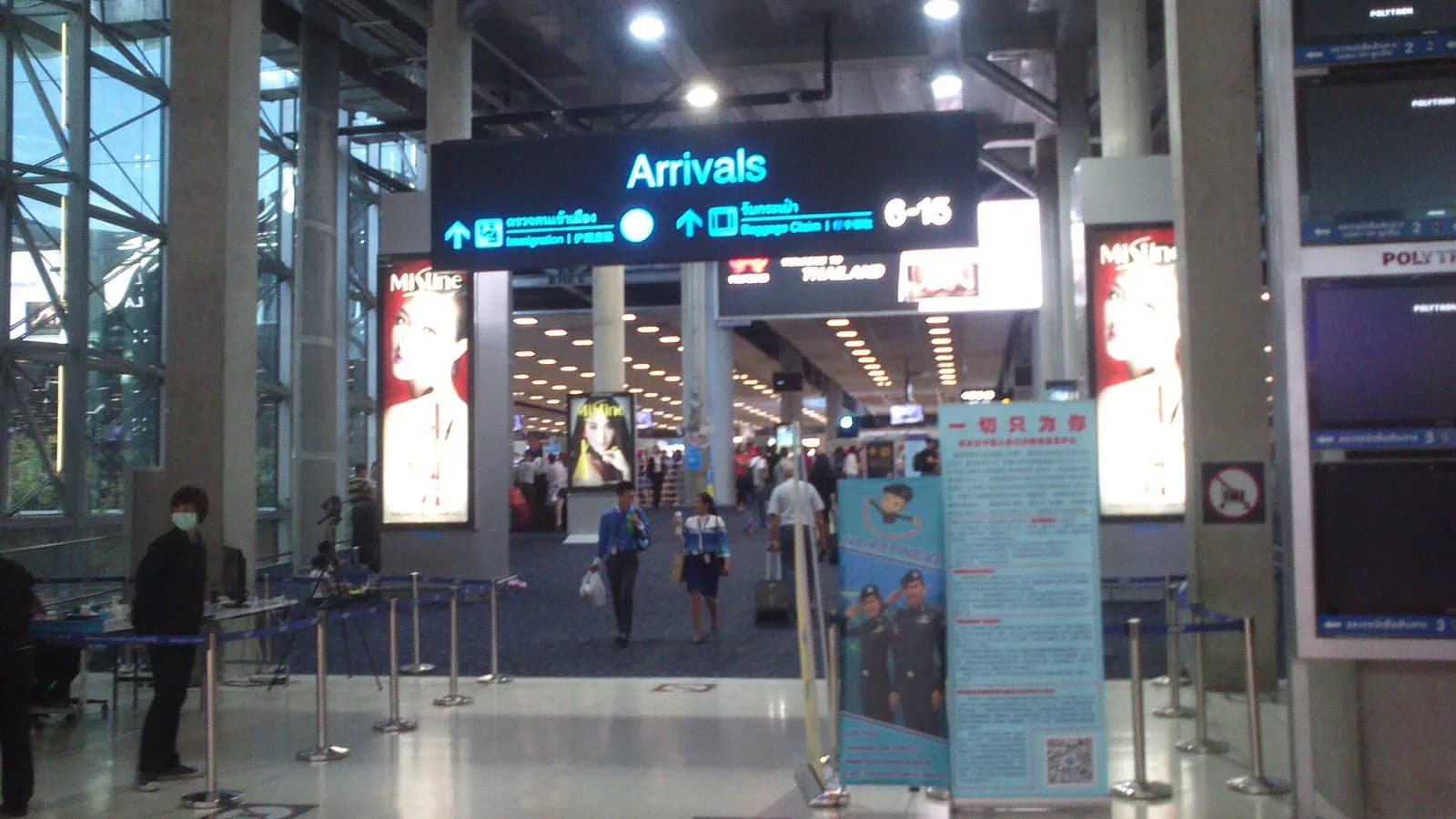 The international arrivals gateway entrance with glass facade and signage welcoming passengers into Suvarnabhumi Airport.