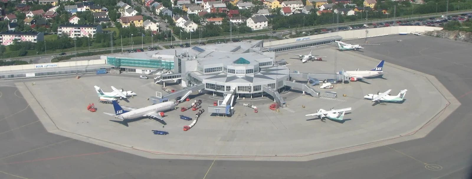 Wide view of Bodø Airport terminal and apron on the peninsula tip.