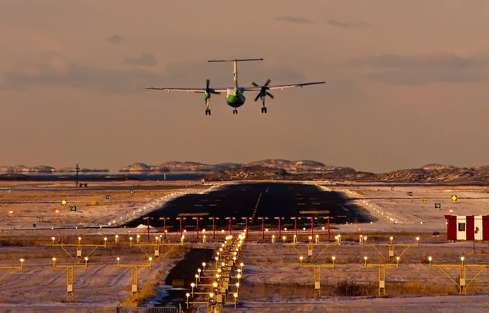 Widerøe Dash 8 on short final into Bodø Airport over the peninsula.