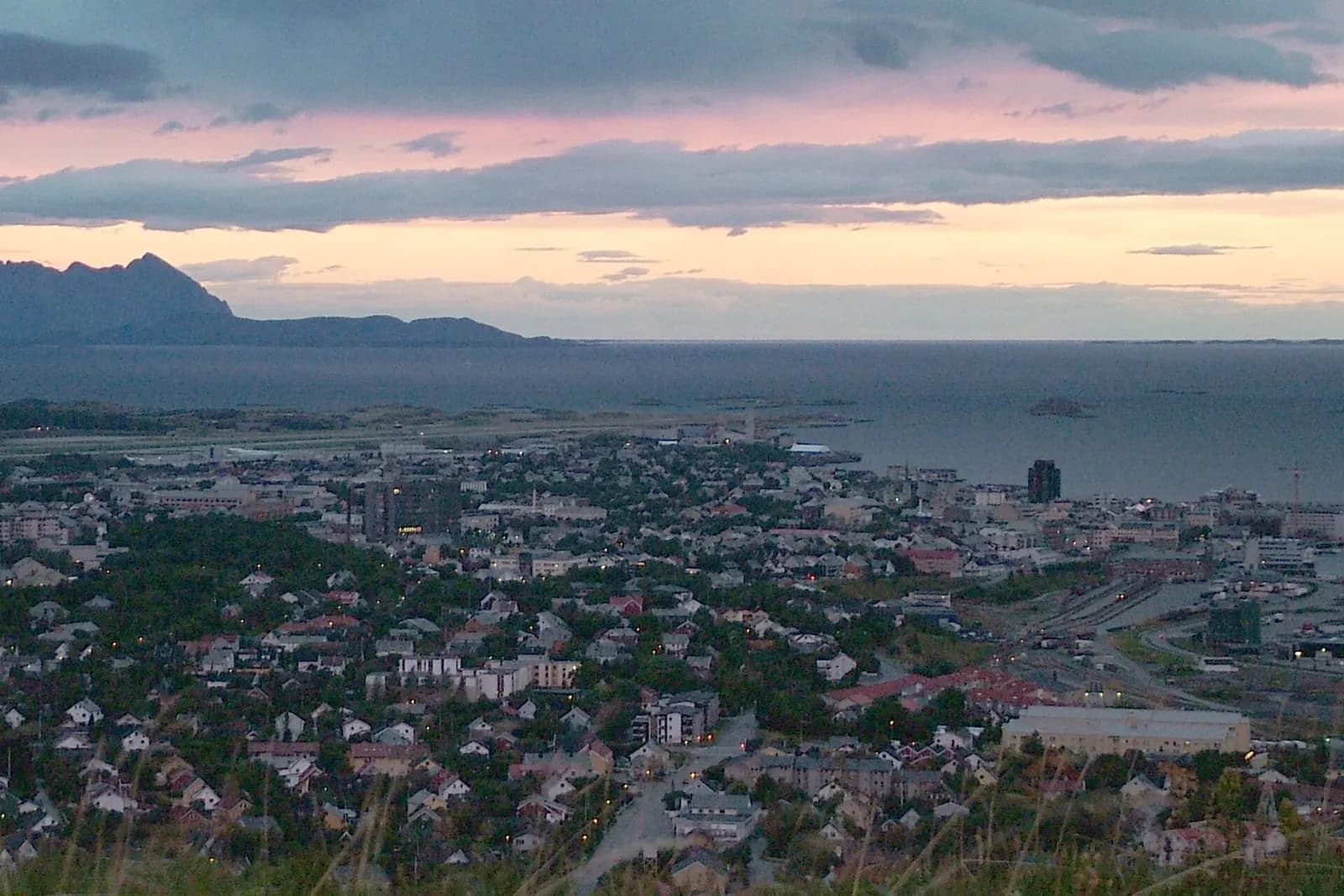 Late-summer sunset light over Bodø, with the airport peninsula under low northern sun.