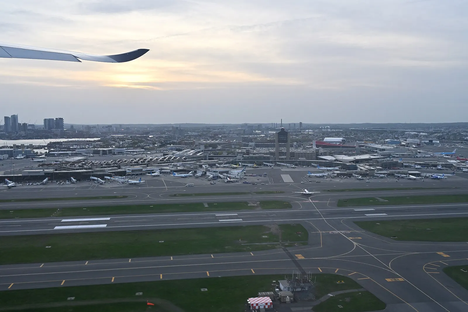 Boston Logan International Airport spreads below as a departing aircraft lifts off from runway 22L.