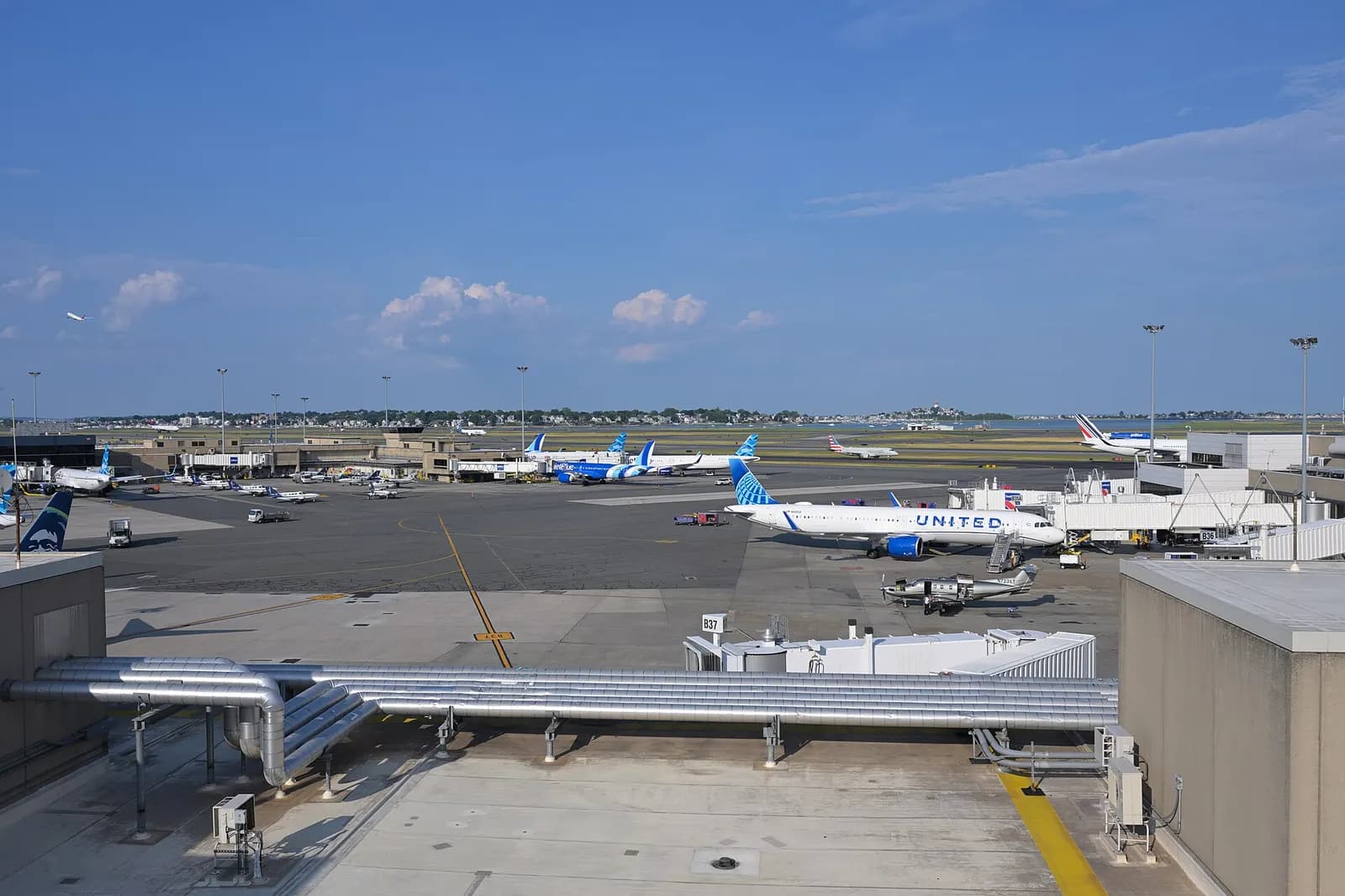 Jet bridges and parked aircraft at the upper Terminal B gates and lower Terminal C gates, seen from the Terminal B parking garage.