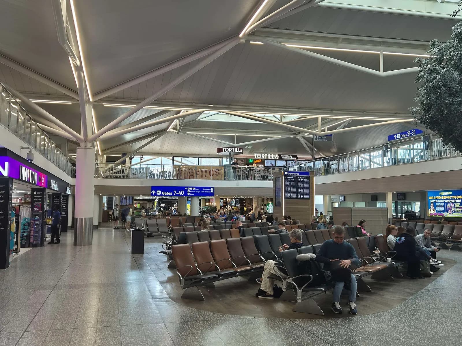 Seating and retail in the Bristol Airport airside waiting area near the gates
