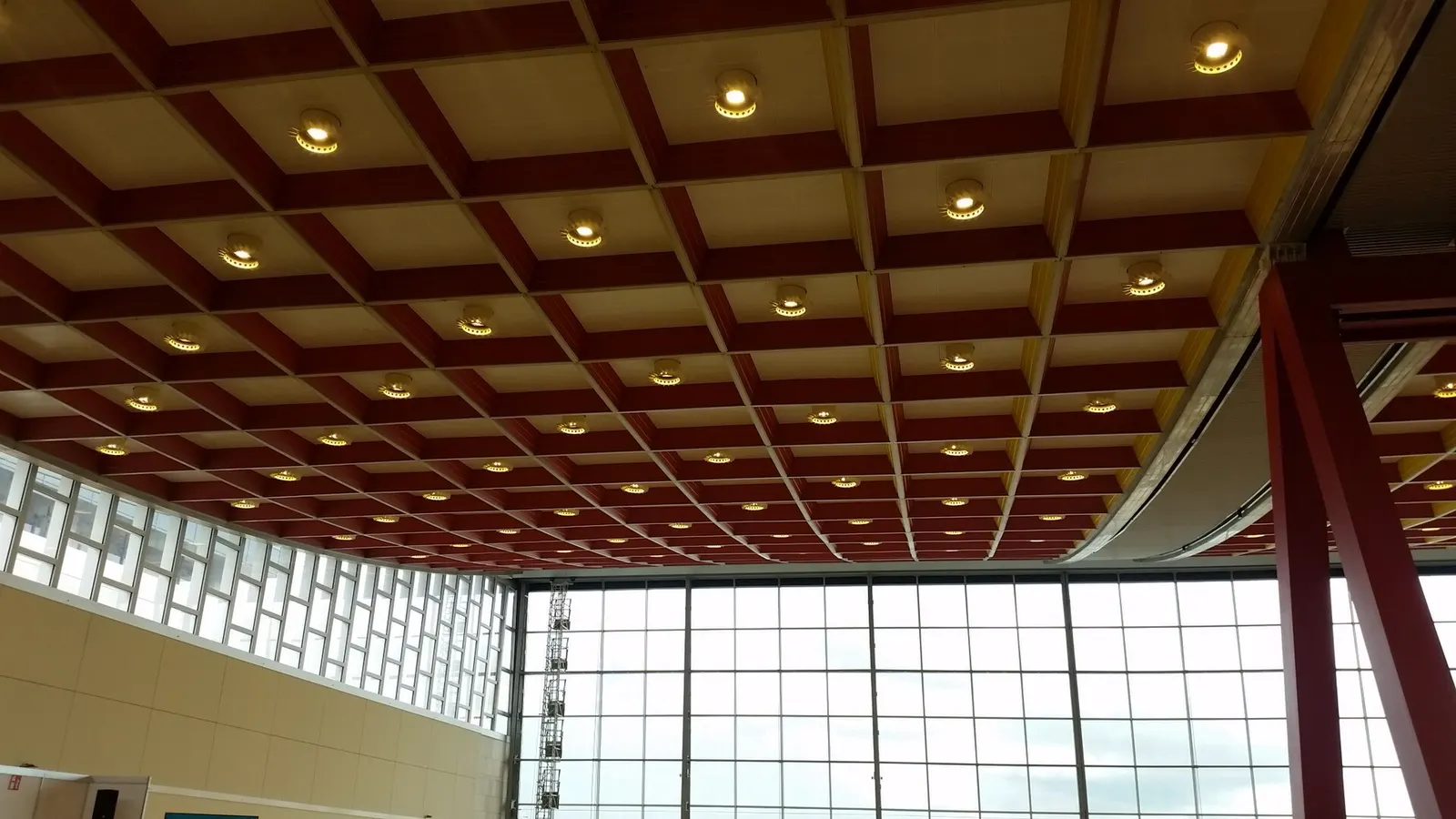 The curved glass-and-steel facade of the Brussels Airport Skyhall building above the departure level.