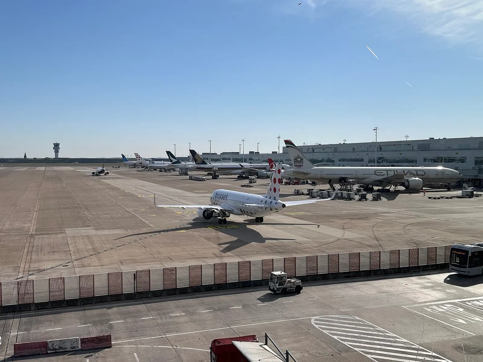 Several international airline jets parked at Pier B jet bridges at Brussels Airport, including Brussels Airlines, Ryanair, Etihad, Turkish Airlines, and United aircraft.