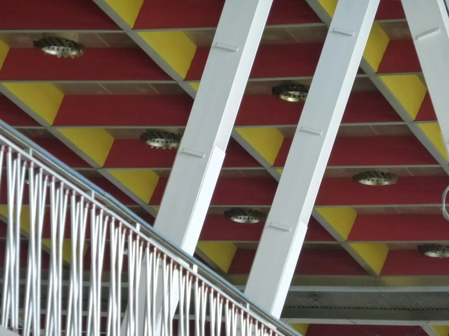 The glazed ceiling and steel framework of Brussels Airport's historic glass departure hall, photographed from inside the terminal.