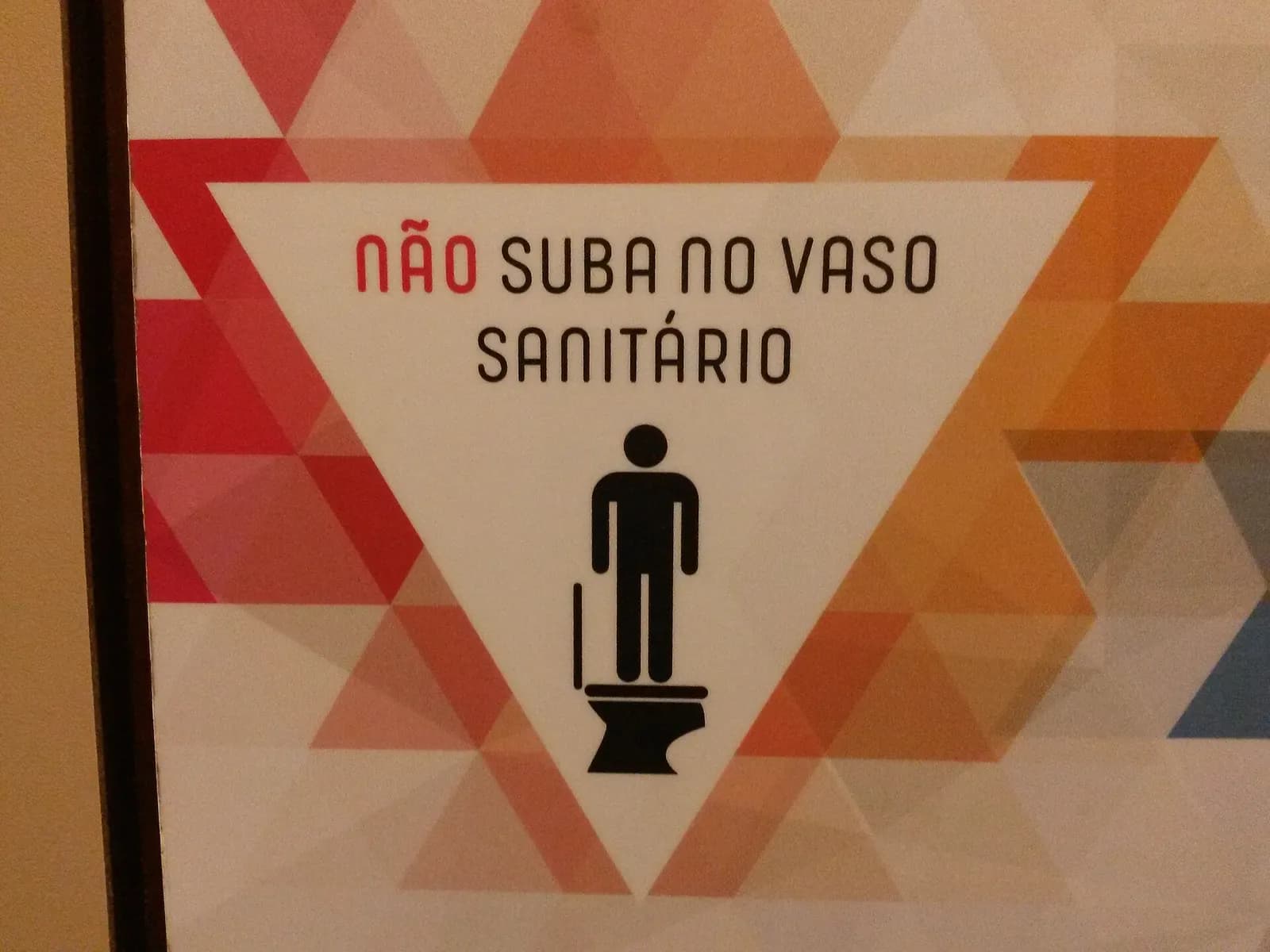 Toilet warning sign at Brasilia Internation Airport: do not climb on the toilet.