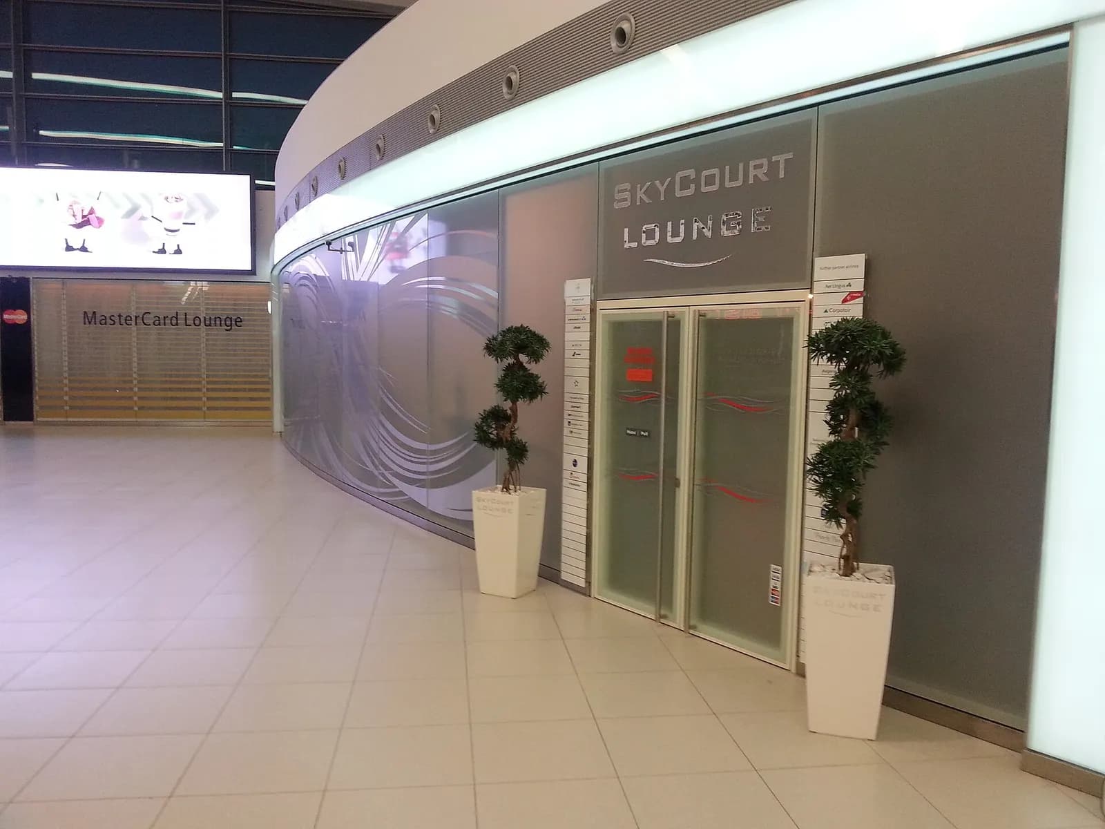 The marked entrance to the SkyCourt Lounge in Terminal 2's gallery area, with lounge branding beside the doorway.