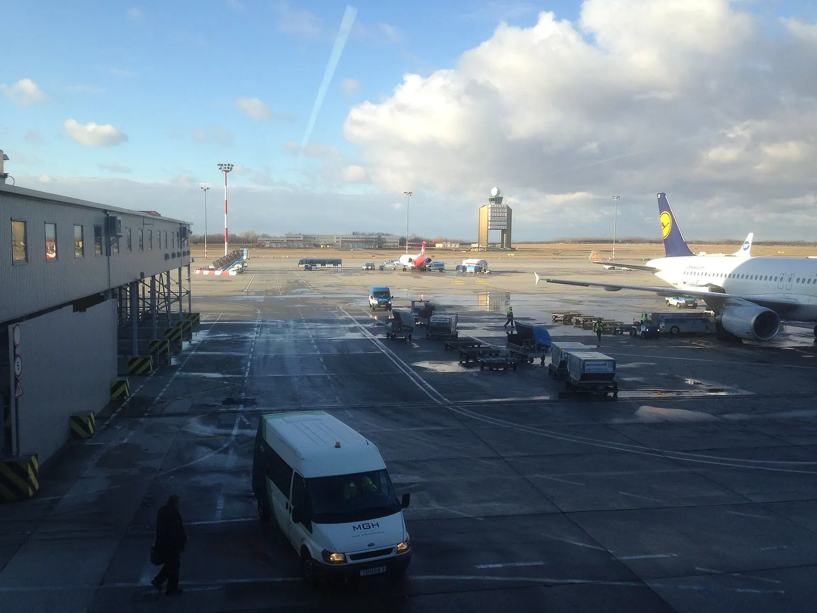 A ground-level view across the airfield toward the Budapest Airport control tower and the Terminal 2 buildings.