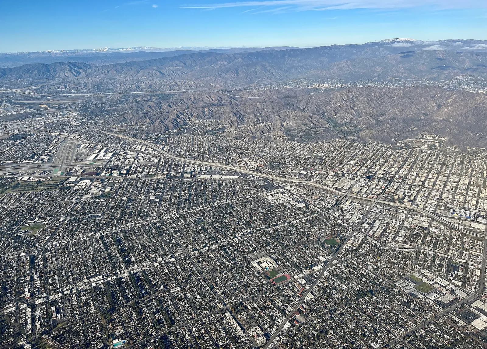 An aerial view of Burbank, CA. In this photo looking north, Hollywood Burbank Airport can be seen on the far left. Interstate 5 Freeway can be seen separating Burbank's halves. The Verdugo Mountains can be seen above Burbank's foothill communities (primarily residential). Notably, the 456,000 sq ft 