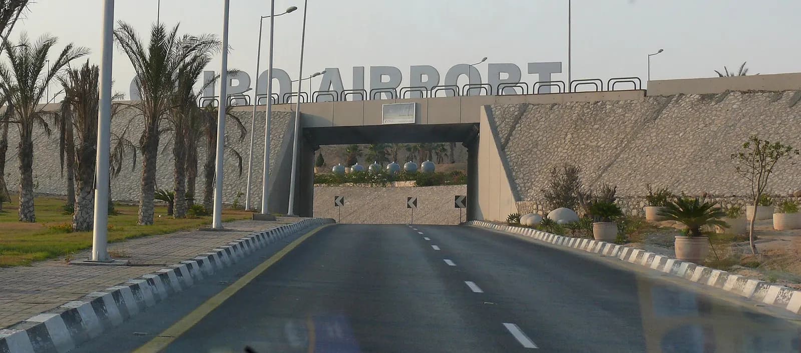 The main roadside entrance to Cairo International Airport, with signage and approach lanes for arriving vehicles.
