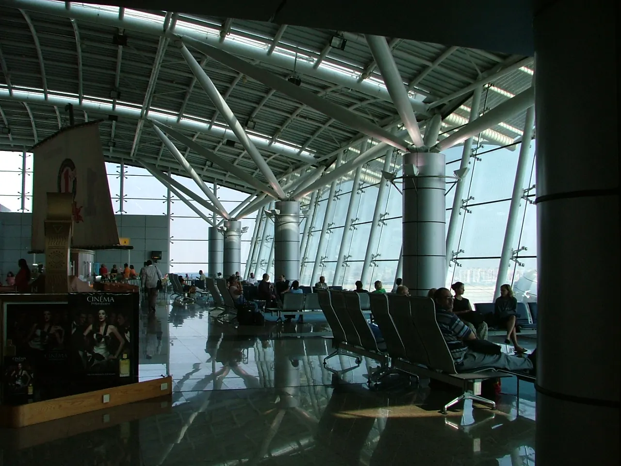 The interior concourse of Terminal 1 at Cairo International Airport with high ceilings, shops, and passenger walkways.