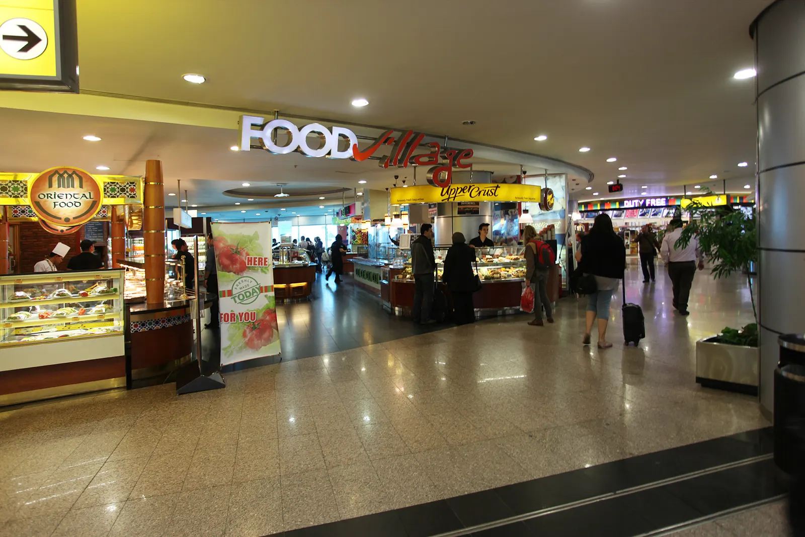 The Food Village dining area in Terminal 3 with multiple restaurant counters and seating for passengers.