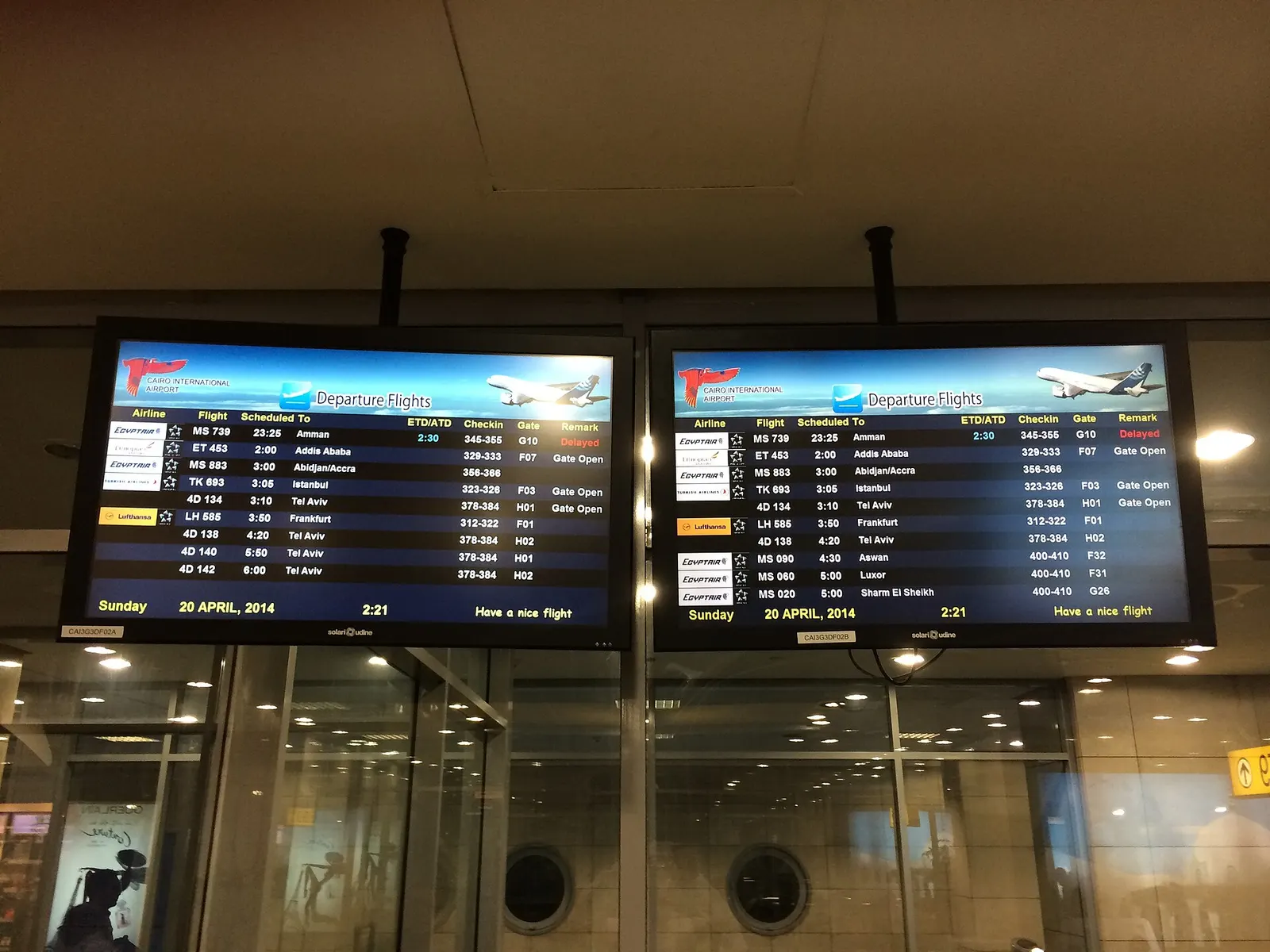 A digital departure board at Cairo International Airport listing Air Sinai and other flight information.