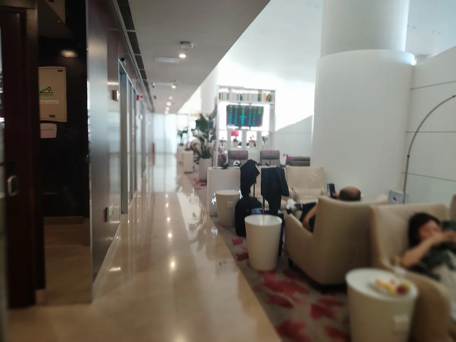 The China Southern Pearl Club premium lounge with upholstered seating, dining tables, and buffet counters for business- and first-class passengers.