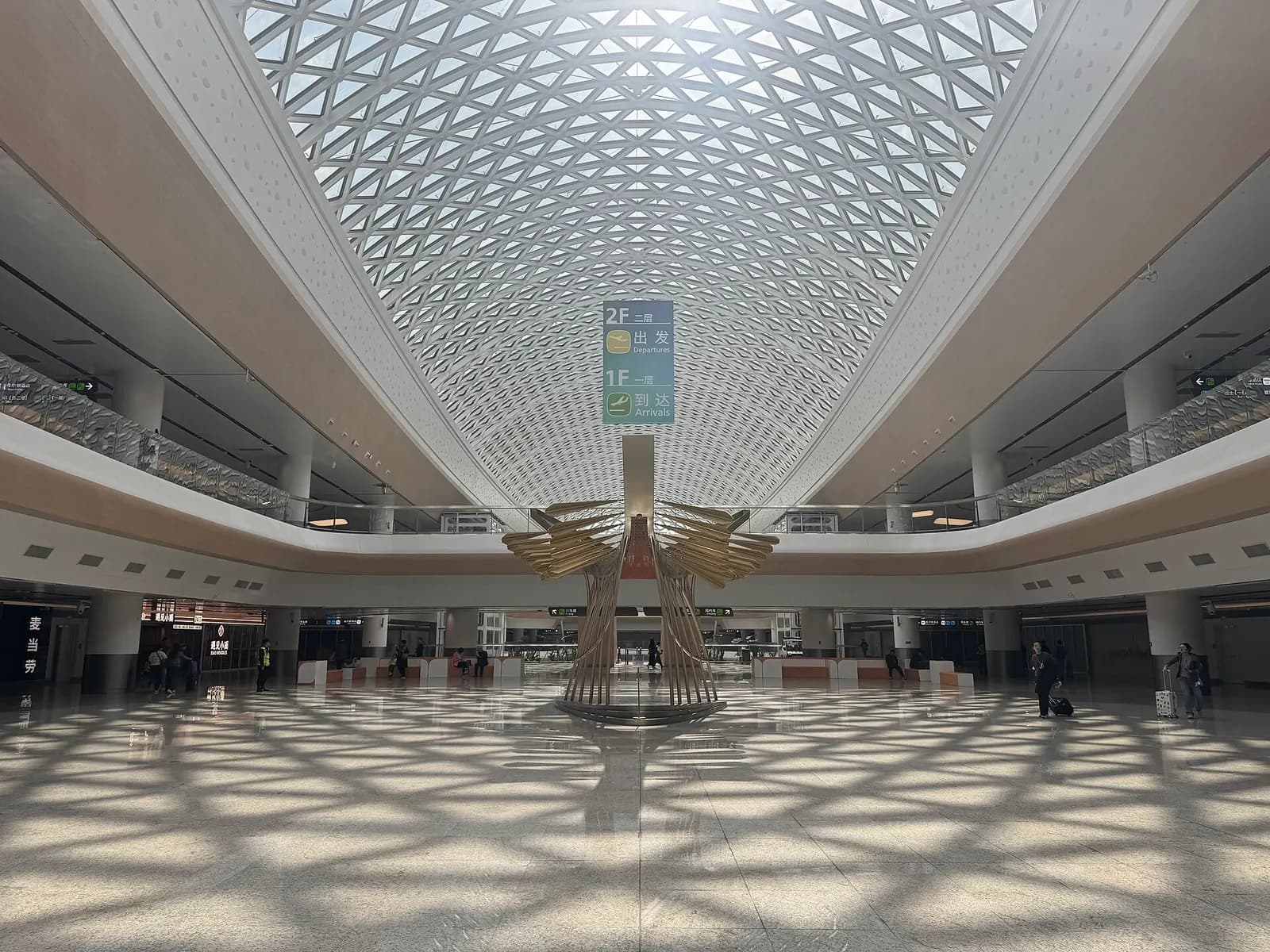 The spacious Terminal 3 Ground Transportation Center with escalators, glass walls, and signage for buses, metro, taxis, and parking.