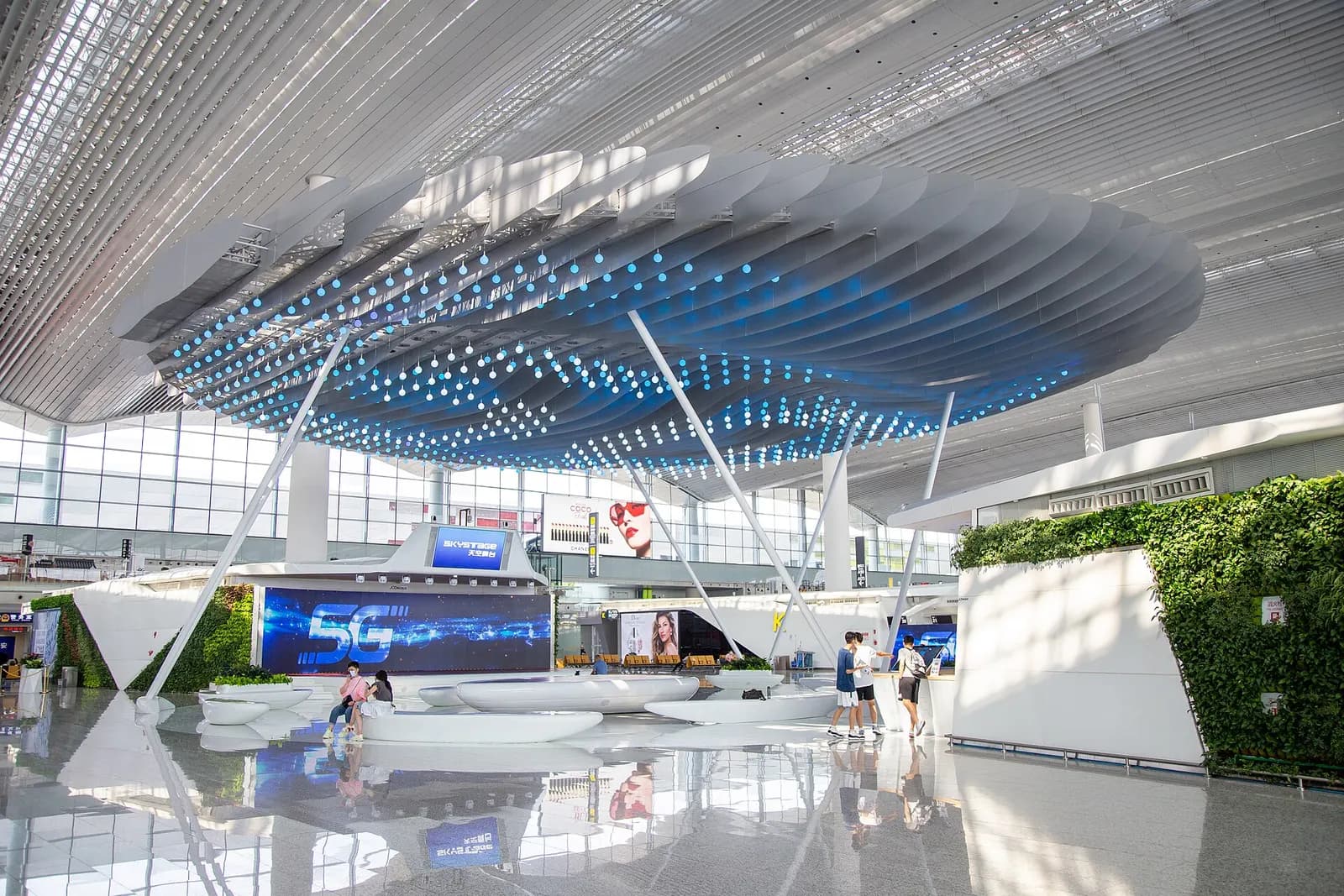 The Terminal 2 departure hall's Sky Stage, a multi-story open atrium with skylights, balconies, shops, and passengers below.